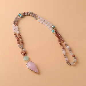 Vue détaillée du pendentif en pointe de flèche quartz rose et collier mala en pierres.