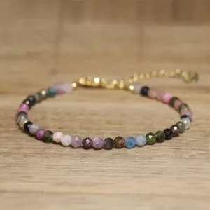 Macro detail view of handmade faceted natural stone bead bracelet with gold chain