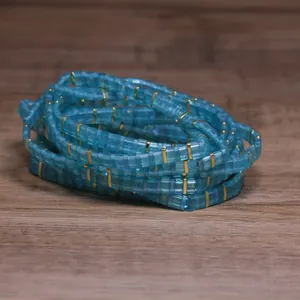 Macro detail of handmade blue Japanese Tila glass bead bracelet with gold accents