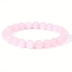 Detailed view of round 8mm rose quartz beads on an elastic stretch jewelry bracelet