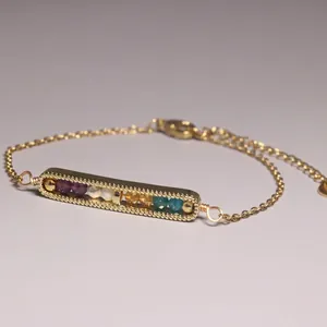 Detailed view of a gold plated bar bracelet featuring colorful natural gemstone beads.