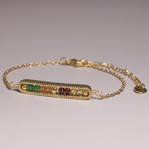 Detailed macro view of a gold-plated bar bracelet set with natural gemstone beads