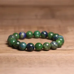Detailed close-up of 8mm natural green India Agate beaded bracelet on wooden table