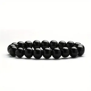 Close-up macro detail of a glossy 8mm black obsidian beaded elastic healing bracelet.