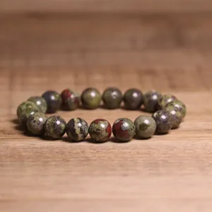 Detail view of 8mm natural Indian agate stone beaded bracelet on rustic wood surface