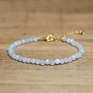 Close-up of faceted pale blue stone beaded bracelet with gold adjustable clasp