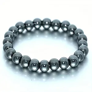 Detailed macro view of high-shine 8mm metallic hematite stone beads on elastic bracelet.