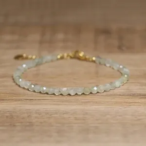 Detail of a faceted natural stone beaded bracelet with a gold adjustable clasp.