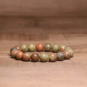 Detailed view of 8mm natural Indian agate beaded bracelet on wooden background