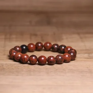Close-up of 8mm natural mahogany obsidian beaded bracelet on wooden background.