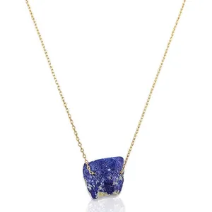 Detalle de un colgante de piedra natural azul en una cadena de acero inoxidable dorada
