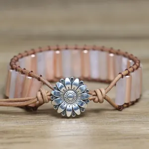 Macro view of natural pink stone wrap bracelet with silver sunflower button clasp