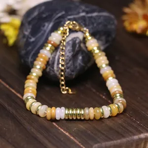 Dettaglio macro del bracciale con perle di pietra naturale e catena d'oro regolabile