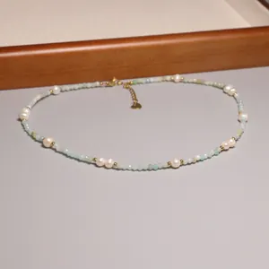 Détail d'un collier de perles fait main avec perles d'eau douce et pierres bleues