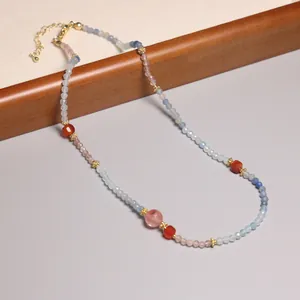 Détail d'un collier de perles colorées de style vintage avec des accents dorés élégants