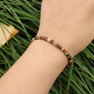Gros plan d'un bracelet artisanal en perles de pierre naturelle Picasso sur un poignet