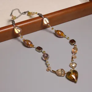 Vue détaillée d'un collier en perles de verre vintage avec un pendentif cœur ambre