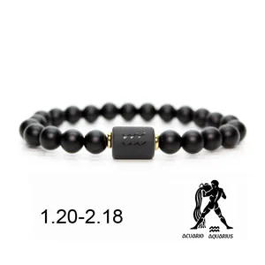 Detalle de la pulsera de cuentas de piedra negra con el signo zodiacal de Acuario grabado.