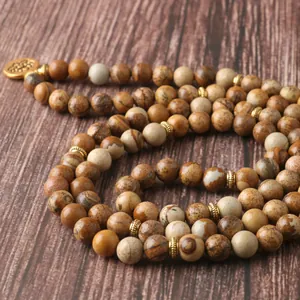 Collier mala 108 perles en pierre naturelle avec pendentif lotus doré sur fond bois