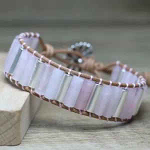 Detailed close-up of natural rose quartz cylinders and silver spacers on leather cord