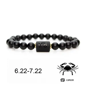 Vista detallada de pulsera de cuentas de piedra negra mate con el signo de Cáncer