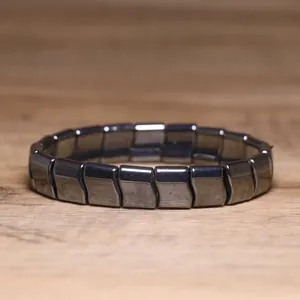 Close-up detail of a minimalist black hematite bead bracelet with elastic cord