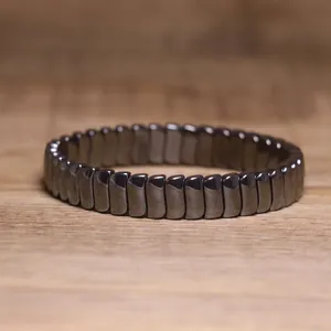 Macro detail of metallic hematite stone bracelet with elastic cord