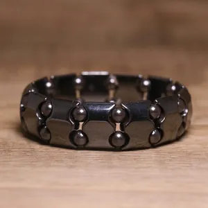 Macro view showing details of black hematite bead and block bracelet with elastic cord