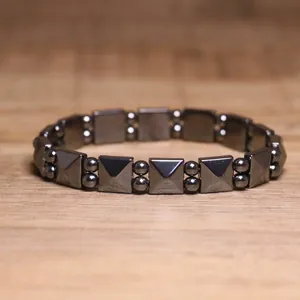 Detailed view of a dark grey hematite elastic bracelet with geometric beads.