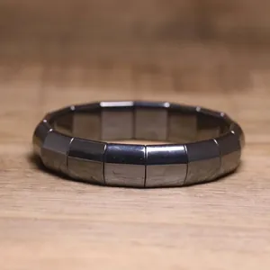 Detailed view of dark gray hematite bracelet with polished rectangular metallic beads