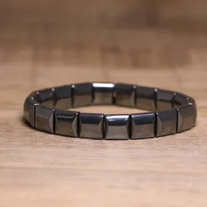Macro view of minimalist geometric hematite bead elastic bracelet on a wooden surface