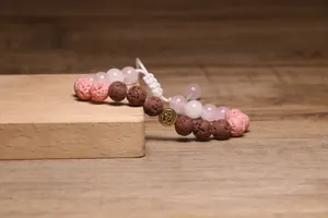 Macrodetail van een handgemaakte lavastenen armband met Om-bedel en geweven koord