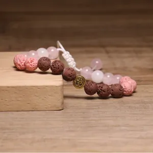 Handgemaakte lavasteen en rozenkwarts kralenarmband met geweven touw en Om-bedel