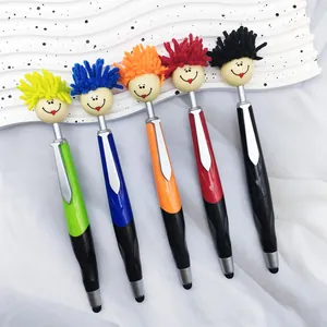 Detail view of five colorful doll head pens with stylus tips on a wavy tray