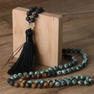 Detail of handmade natural stone beaded necklace with black tassel and crystal pendant