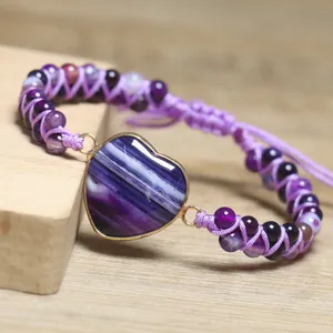 Detaillierte Ansicht des lila Naturstein-Herzpendant am handgewebten Perlenarmband