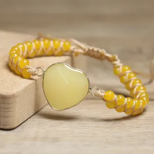 Detaillierte Nahaufnahme eines handgefertigten gewebten Armbands mit gelben Herzsteinperlen