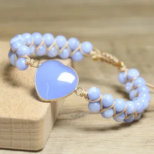 Detail mit herzförmigem lila Stein und blauem Perlengeflecht des verstellbaren Armbands
