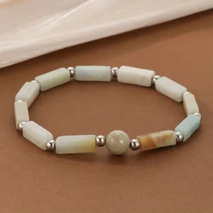 Close-up of natural stone bead bracelet with rectangular amazonite beads and silver spacers.