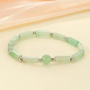 Detailed view of a natural green stone beaded bracelet with silver spacers.