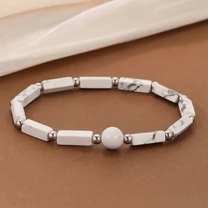 Close-up of a stylish white marble texture stone bead bracelet with silver separator accents