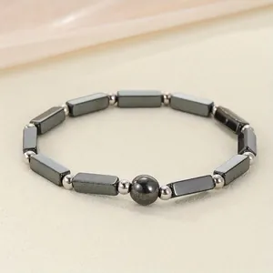 Close-up macro view of a black hematite magnetic energy bead bracelet for women