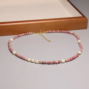 Gros plan d'un collier de perles roses avec perles d'eau douce naturelles et dorées