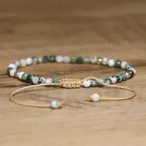 Detailed view of faceted moss agate beads and adjustable woven gold thread knot closure