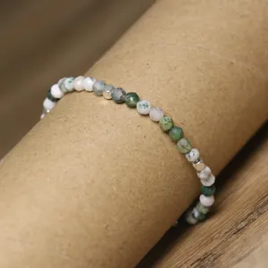 Detailed view of 4mm faceted natural green agate beaded bracelet on rustic kraft paper