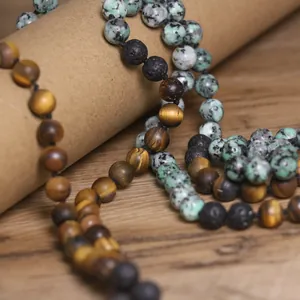 Detalle de un collar hecho a mano con cuentas de ojo de tigre y piedra de lava.
