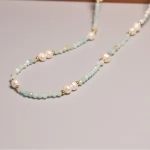 Collier élégant en perles d'eau douce naturelles et perles de verre bleues.