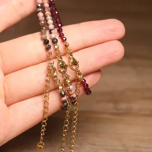 Detail view of handmade natural tourmaline beaded bracelets with gold-tone lobster clasps.