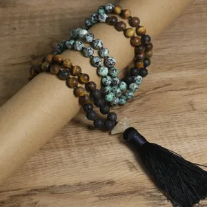 Vista detallada del collar mala de cuentas hecho a mano con borla negra sobre madera