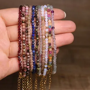 Close-up of multiple colorful faceted natural stone beaded bracelets with gold chains